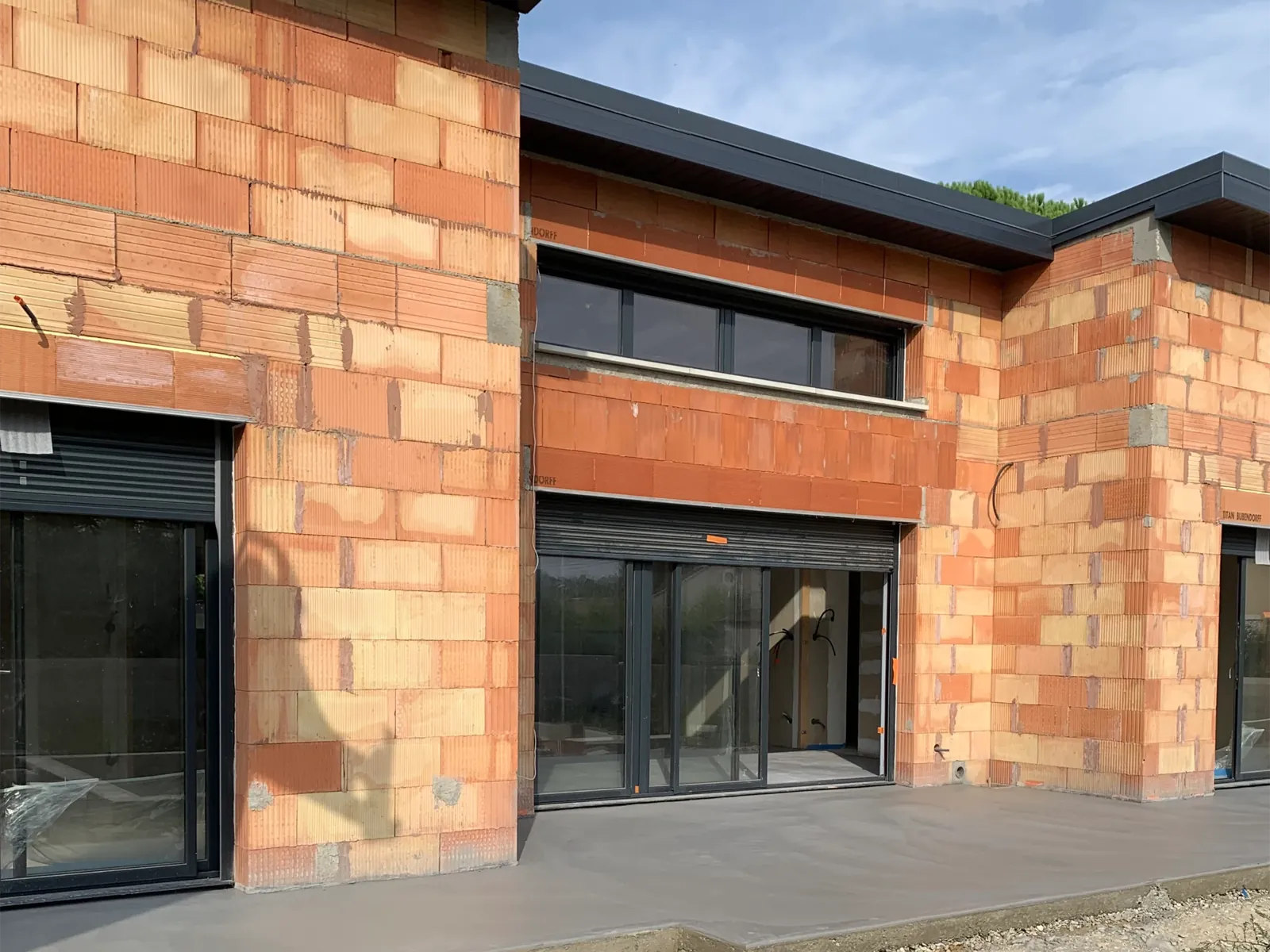 Façade en briques et menuiseries aluminium d'une construction neuve à Montélimar